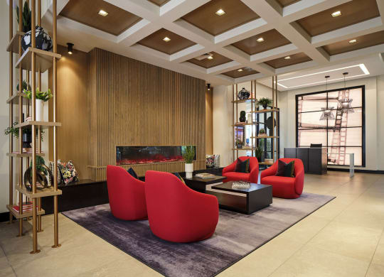 a living room with red chairs and a fireplace