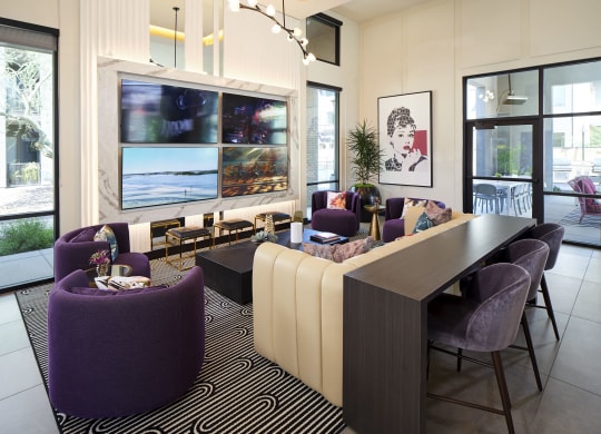 a living room with purple chairs and a table