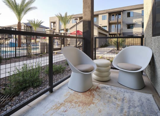 two toilets sitting on a balcony next to a fence
