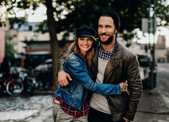 a man and a woman hugging on the street