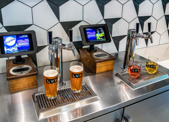 a bar with glasses of beer on a stainless steel counter