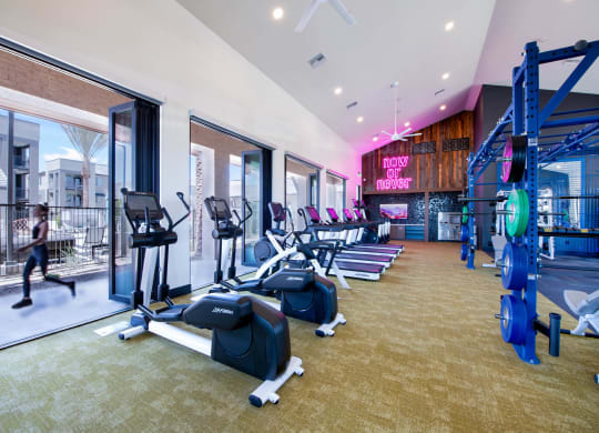 a gym with cardio equipment and windows at aria resort and spa