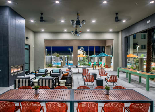 a lounge area with tables and chairs and a fireplace