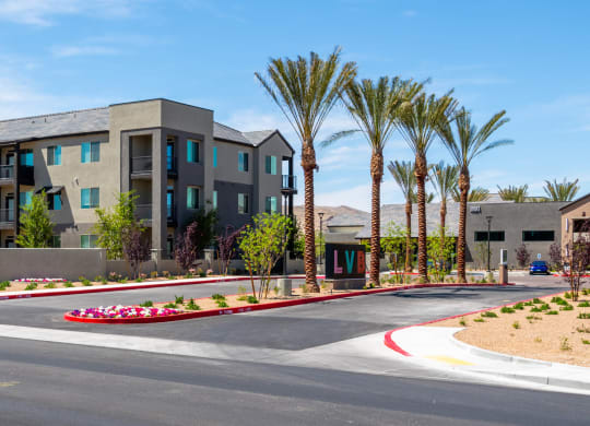 a street view of an apartment building with palm trees