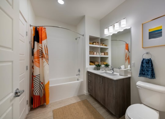 a bathroom with a shower and a sink and a toilet