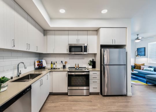 a kitchen with white cabinets and stainless steel appliances