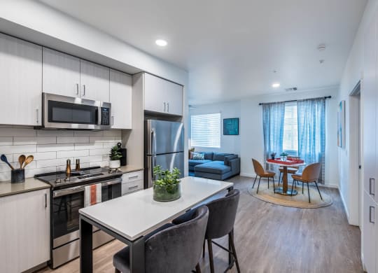 a kitchen and living room with a table and chairs