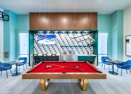 a red pool table in a room with a bar and a scoreboard