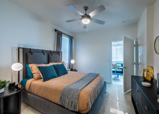 a bedroom with a bed and a ceiling fan
