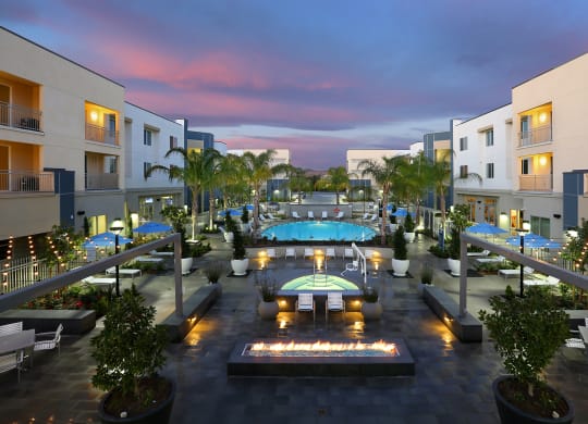 a view of a resort with a swimming pool at night