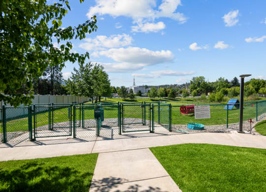 a fenced in area of a park with playground equipment