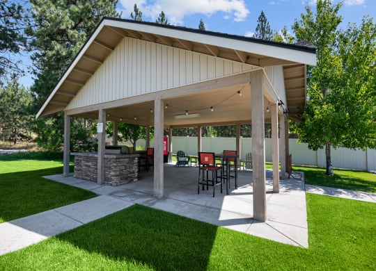 a covered patio with a table and chairs under a pavilion