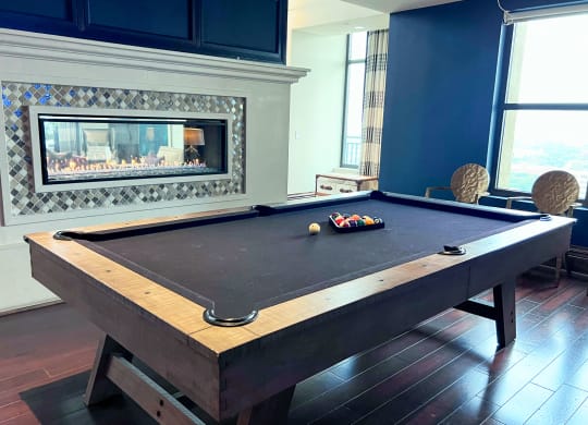 a pool table in a living room with a fireplace