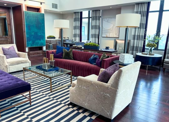a living room with couches and chairs and a striped rug