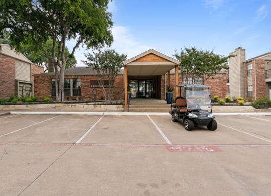 a golf cart sits in a parking lot in front of a brick building