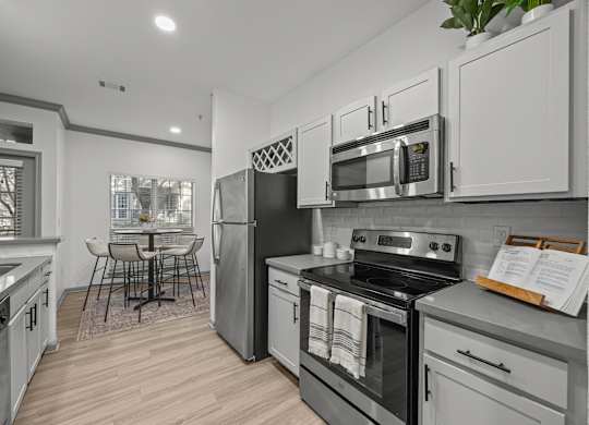 A modern kitchen with stainless steel appliances and white cabinets.