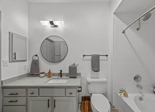 A bathroom with a white tub, toilet, and sink.