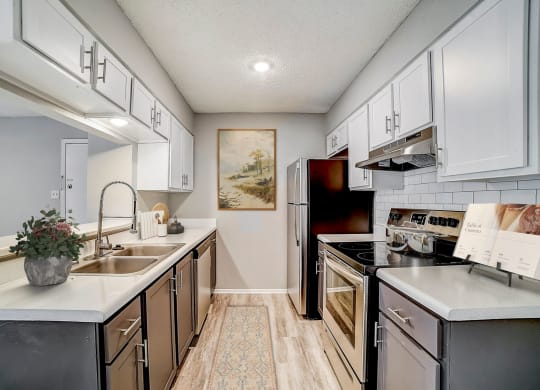 a kitchen with white cabinets and black appliances