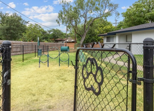 a backyard with a playground and a house in the background