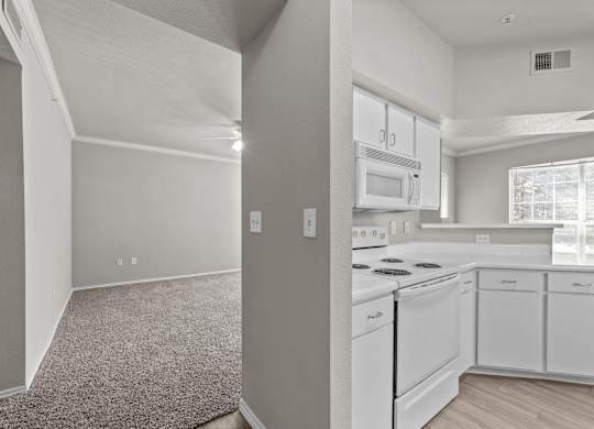 A kitchen with white appliances and cabinets.