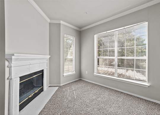 A room with a fireplace and a window with blinds.