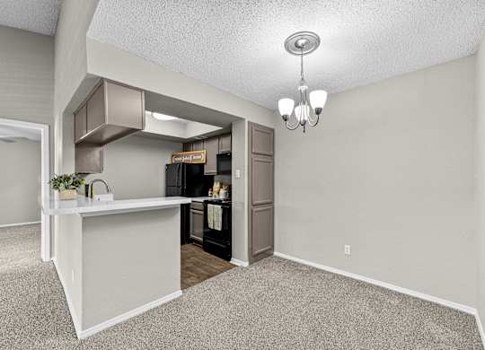A kitchen area with a white counter and a refrigerator.