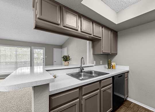 A kitchen with brown cabinets and a white countertop.