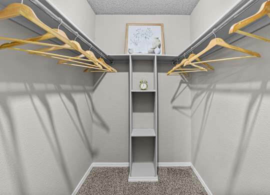A small closet with a shelf and hangers.