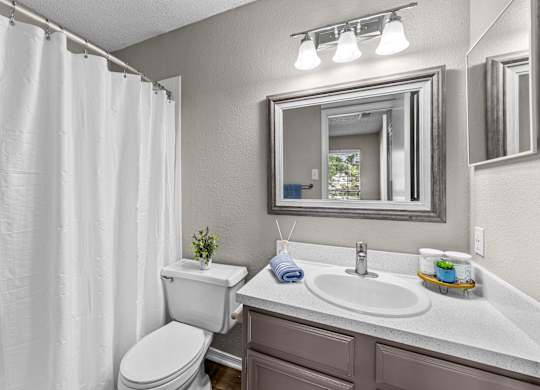 A white toilet sits next to a sink in a bathroom.