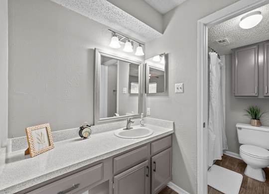 A bathroom with a white sink and a white toilet.