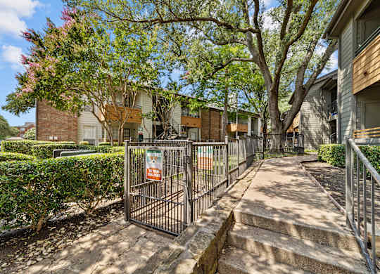 A gated entrance to a residential area with a sign on the gate.