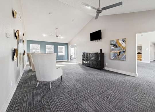 A living room with a grey carpet and a white chair.