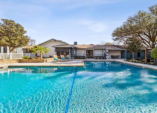 A swimming pool in front of a house.