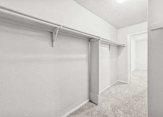 A white room with a carpeted floor and a white wall.