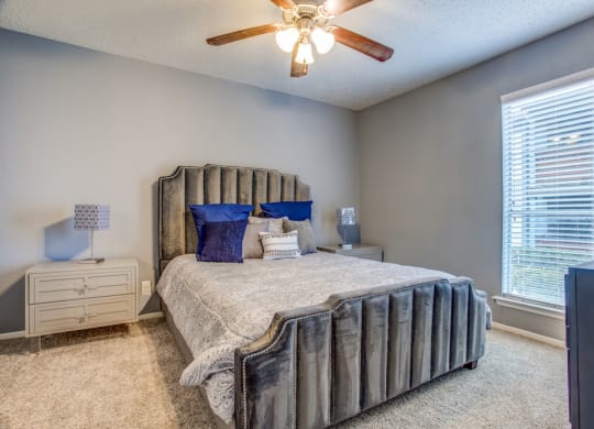 a bedroom with a bed and a ceiling fan