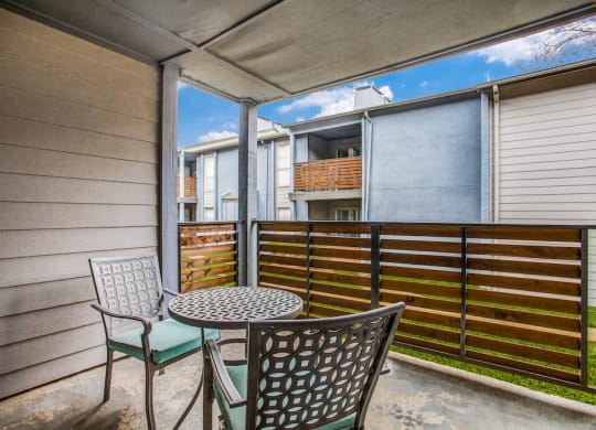 a patio with chairs and a table with a basket on top of it