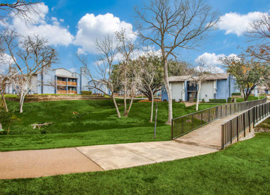 a sidewalk leading to a house in a park