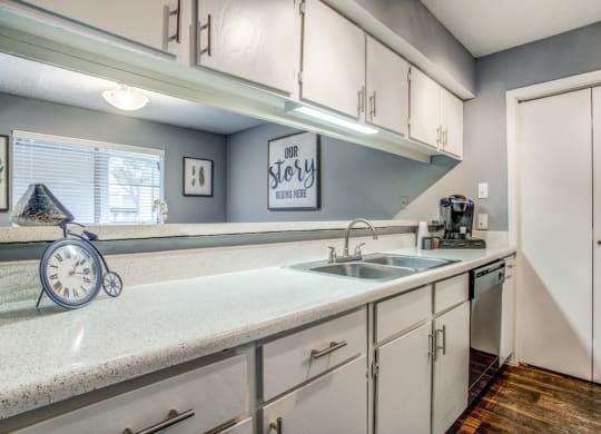 a kitchen with white cabinets and a white counter top