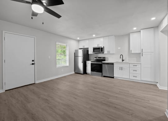 the living room and kitchen of a home with white walls and white cabinets at Sunset Heights, San Antonio, TX, 78209