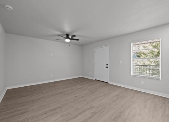 an empty living room with a ceiling fan and a window at Sunset Heights, San Antonio, 78209