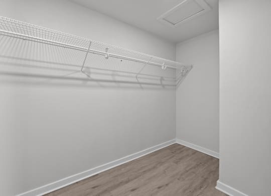 an empty bedroom with white walls and a white closet with a white rack on top at Sunset Heights, Texas, 78209