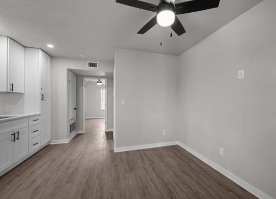 an empty living room with white walls and a ceiling fan  at Sunset Heights, San Antonio