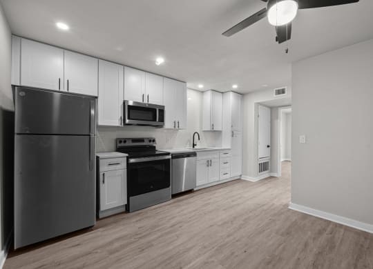 an empty kitchen with white cabinets and stainless steel appliances at Sunset Heights, Texas