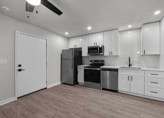 an empty kitchen with white cabinets and stainless steel appliances at Sunset Heights, Texas, 78209