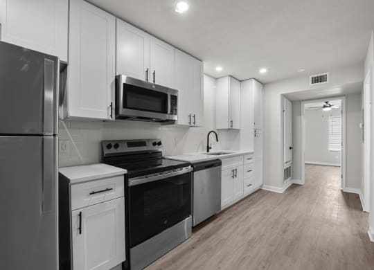 Photo of newly renovated kitchen with stainless steel appliances and white cabinetry at Sunset Heights, San Antonio, 78209