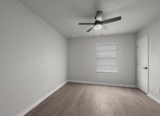 an empty living room with a ceiling fan and a door at Sunset Heights, San Antonio, TX