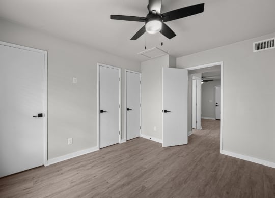 an empty living room with white walls and a ceiling fan at Sunset Heights, Texas