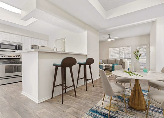 a living room with a kitchen and a dining table