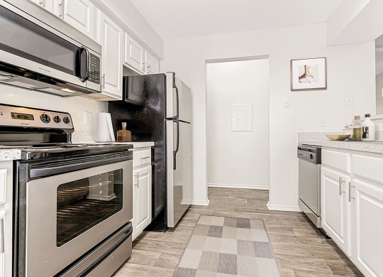 a kitchen with stainless steel appliances and white cabinets