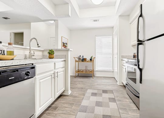 a renovated kitchen with white cabinets and stainless steel appliances